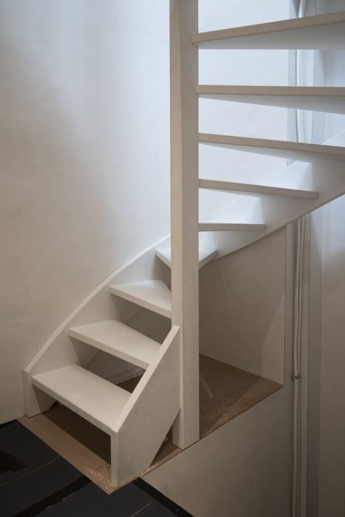 Witte basis trap met houten treden en stalen balustrade